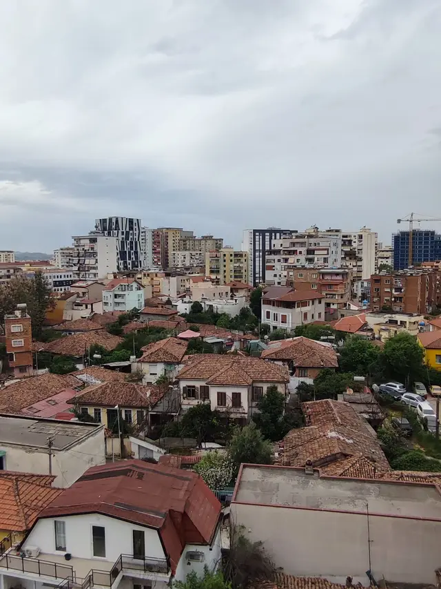 Terracotta rooftops of old Tirana with the new skyline behind